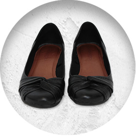 A photo of a pair of black ballet-style pumps.