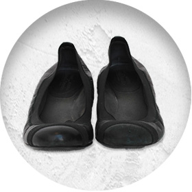 A photo of a pair of black ballet-style pumps.