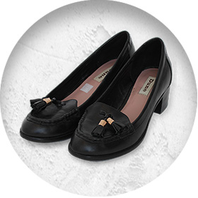 A photo of a pair of smart black leather low-heeled court shoes with small tassles on the front.