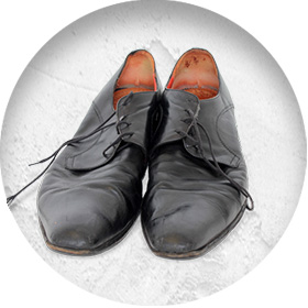 A photo of a pair of well-worn smart black leather shoes.
