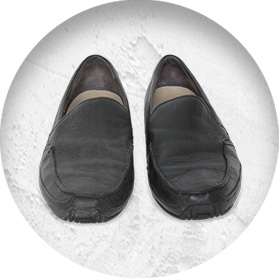 A photo of a pair of smart black leather slip-on shoes.