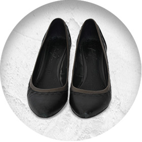 A photo of a pair of smart black leather court shoes.