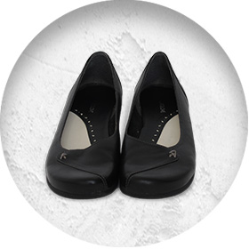 A photo of a pair of smart black leather court shoes.