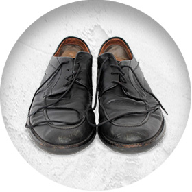 A photo of a pair of well-worn smart black leather shoes.